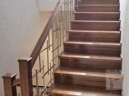 Лестница из массива дуба с подступенками с кованым ограждением